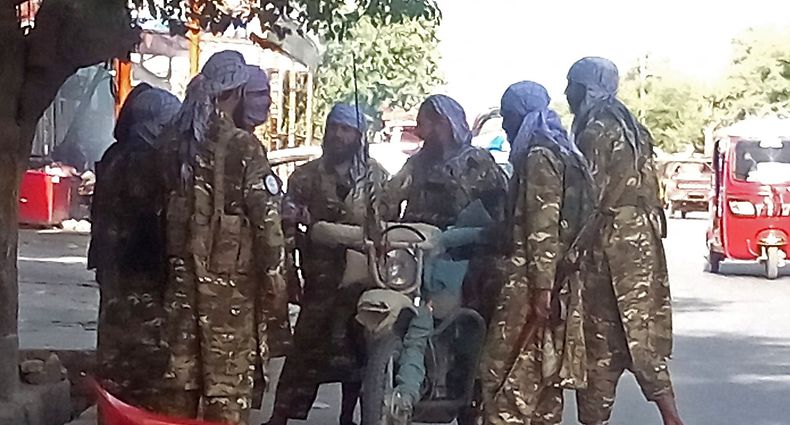 In this picture taken on August 9, 2021, Taliban fighters stand along a road in the northern city of Kunduz that was captured by the Taliban over the weekend as 
residents said shops had begun to reopen in the centre as insurgents focused their attention on government forces who had retreated to the airport. (Photo by - / AFP)
