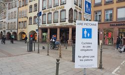 PRODUKTION - 16.01.2023, Frankreich, Straßburg: Ein Schild an der Rue des Grandes Arcades in Straßburg fordert Radfahrer zum langsamen Fahren auf. «Behindern Sie nicht die Fußgänger» - mit übergroßen Schildern fordert die Stadt Straßburg neuerdings Radler im Zentrum auf, Schritt zu fahren. (zu dpa: «Straßburg schützt Fußgänger - und bremst Radler.») Foto: Christian Böhmer/dpa +++ dpa-Bildfunk +++