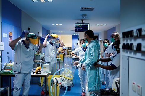 TOPSHOT - Medical workers put on their protective gears before working on March 27, 2020, at the unit for coronavirus COVID-19 infected patients at the Erasme Hospital in Brussels. (Photo by Kenzo TRIBOUILLARD / AFP)