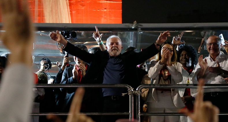 Brazilian former President (2003-2010) and candidate for the leftist Workers Party (PT) Luiz Inacio Lula da Silva, and his wife Rosangela "Janja" da Silva, wave to supporters after learning the results of the legislative and presidential election at Paulista avenue in Sao Paulo, Brazil, on October 2, 2022. - Brazil's bitterly divisive presidential election will go to a runoff on October 30, electoral authorities said Sunday, as incumbent Jair Bolsonaro beat expectations to finish a relatively close second to front-runner Luiz Inacio Lula da Silva. Lula, the veteran leftist seeking a presidential comeback, had 48.1 percent of the vote to 43.5 percent for the far-right President, with 98 percent of polling stations reporting, according to official from the Superior Electoral Tribunal. (Photo by Miguel Schincariol / AFP)