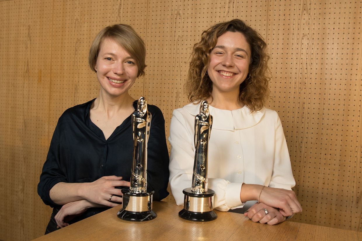 Anna Brüggemann (l) und Aiste Dirziute, die Moderatorinnen der 32. EUROPEAN FILM AWARDS, stehen vor zwei Trophäen.