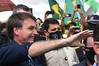 Brazil's President Jair Bolsonaro greets supporters upon arrival at Planalto Palace in Brasilia, on May 24, 2020, amid the COVID-19 coronavirus pandemic. - Despite positive signs elsewhere, the disease continued its surge in large parts of South America, with the death toll in Brazil passing 22,000 and infections topping 347,000, the world's second-highest caseload. (Photo by EVARISTO SA / AFP)
