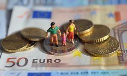 ARCHIV - ILLUSTRATION - Ein Paar mit einem Kind steht auf einer Zwei-Euro-Münze, die auf Geldscheinen liegt, aufgenommen am 16.02.2011. Wegen hoher Mietkosten rutschen einkommensschwache Familien laut einer Studie in vielen größeren deutschen Städten, wie zum Beispiel Frankfurt, unter Hartz-IV-Niveau. Foto: Andreas Gebert dpa (zu dpa/lhe "Studie: Nach Abzug der Miete viele arme Familien unter Hartz-IV" vom 22.07.2013) +++(c) dpa - Bildfunk+++