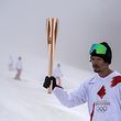 Japanese torchbearer Sho Endo, a freestyle skier and former olympian, carries the Olympic torch during the second day of the Tokyo 2020 Olympic Games torch relay at Inawashiro ski resort in the town of Inawashiro, Fukushima Prefecture on March 26, 2021. (Photo by Charly TRIBALLEAU / AFP)