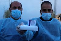 21.02.2021, Palästinensische Autonomiegebiete, Rafah: Palästinensische Mitarbeiter des Gesundheitswesens halten eine Schachtel mit dem russischen Corona-Impfstoff Sputnik V. 20 000 Dosen des Impfstoffs sind im Gazastreifen eingetroffen. Die Lieferung, die von den Vereinigten Arabischen Emiraten gespendet wurde, wurde von Ägypten aus über den Rafah-Grenzübergang in das Palästinensergebiet gebracht. Foto: Ashraf Amra/APA Images via ZUMA Wire/dpa +++ dpa-Bildfunk +++