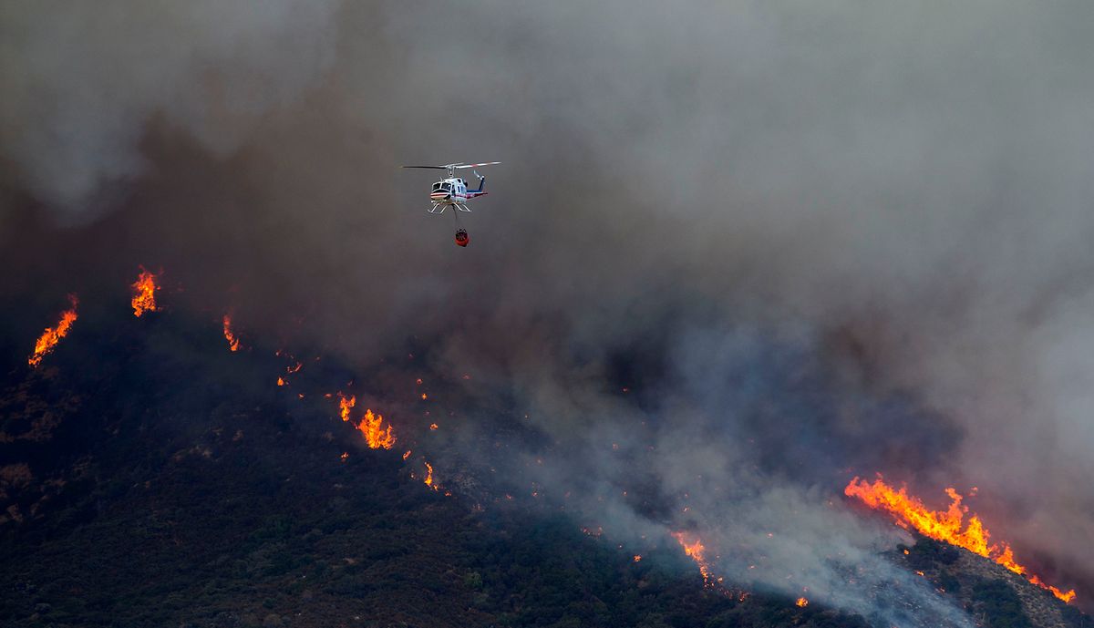 Ein Hubschrauber mit Wasserabwurf beim El Dorado Feuer im Einsatz.  