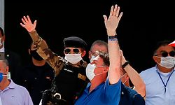 TOPSHOT - Brazilian President Jair Bolsonaro holds a child in a military costume as they both wave during a rally in Brasilia on May 17, 2020, amid the novel coronavirus pandemic. - Brazil's COVID-19 death toll passed 15,000 on Saturday, official data showed, while its number of infections topped 230,000, making it the country with the fourth-highest number of cases in the world. (Photo by Sergio LIMA / AFP)