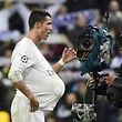 TOPSHOT - Real Madrid's Portuguese forward Cristiano Ronaldo (L) celebrates his hat trick with the ball under his shirt during the Champions League quarter-final second leg football match Real Madrid vs Wolfsburg at the Santiago Bernabeu stadium in Madrid on April 12, 2016. / AFP PHOTO / PIERRE-PHILIPPE MARCOU