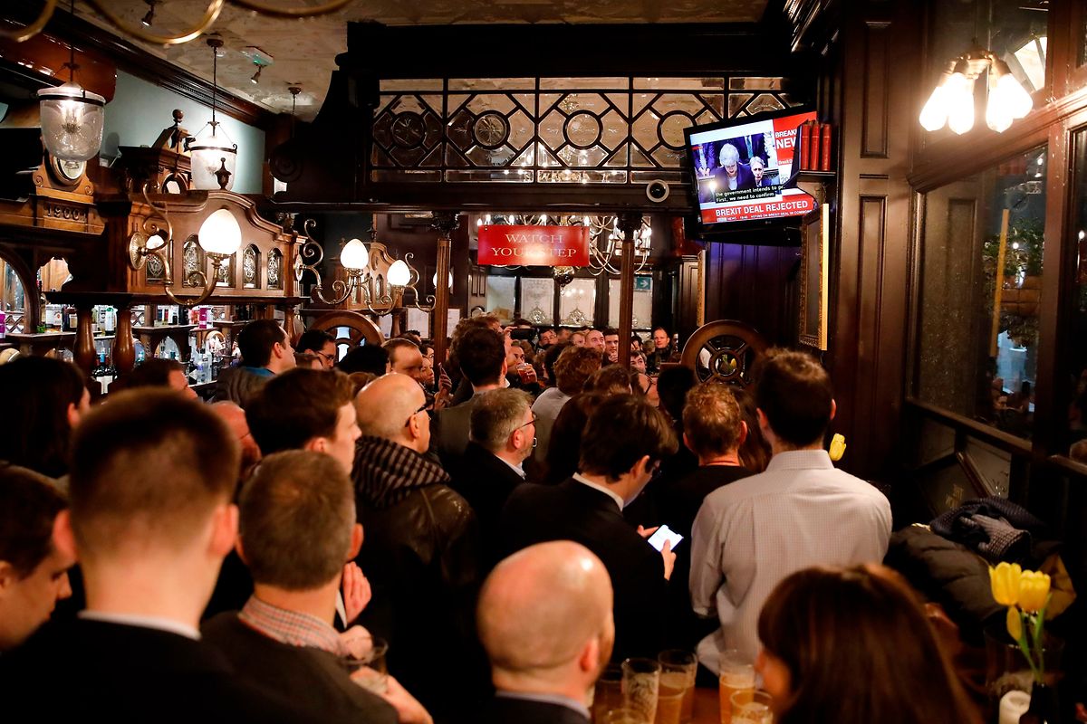 Pessoas observam a votação num pub em Londres