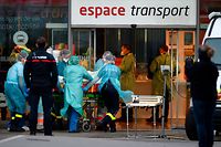 Medical staff carry a patient infected with the novel coronavirus (Covid-19) inside Nancy train station, eastern France, prior to his trasnfer into a medicalised TGV (high-speed train) on March 29, 2020. - Preparations for the evacuation of patients towards hospitals in the region of Nouvelle Aquitaine of 24 coronavirus-contaminated patients from Lorraine aboard a medicalised TGV began Sunday morning at Nancy station. (Photo by JEAN-CHRISTOPHE VERHAEGEN / AFP)