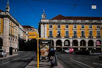 A woman wearing a face mask waits for a bus at Comercio square in Lisbon on January 7, 2021. - Portugal reported a record 10,000 new coronavirus cases in 24 hours yesterday, and the government warned that its hospitals were under "enormous pressure" from the resurgence of the pandemic. (Photo by PATRICIA DE MELO MOREIRA / AFP)