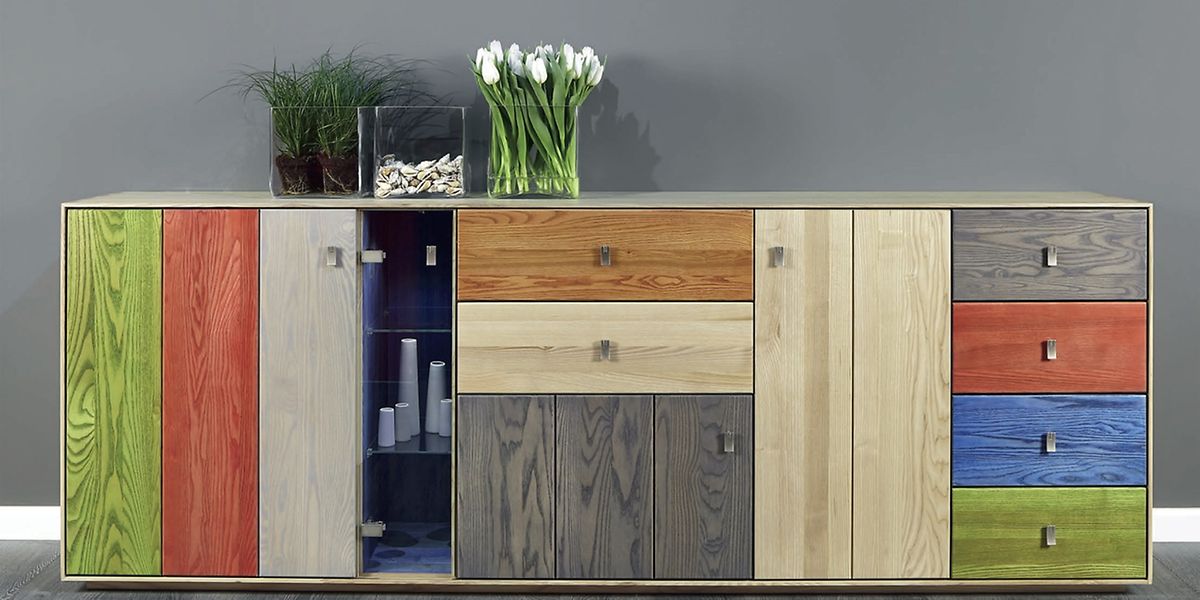 Die schlichte Kommode wird durch recycelte Holzpaneele und bunte Lasuren aufgepeppt.

