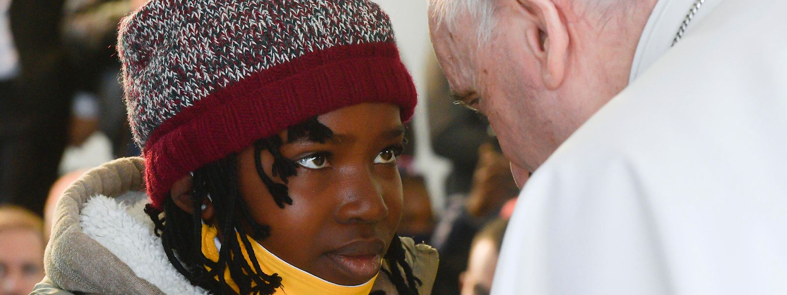 Papst Franziskus (r) spricht während seines Besuchs im Migrantenlager Camp Kara Tepe mit einem Mädchen. 