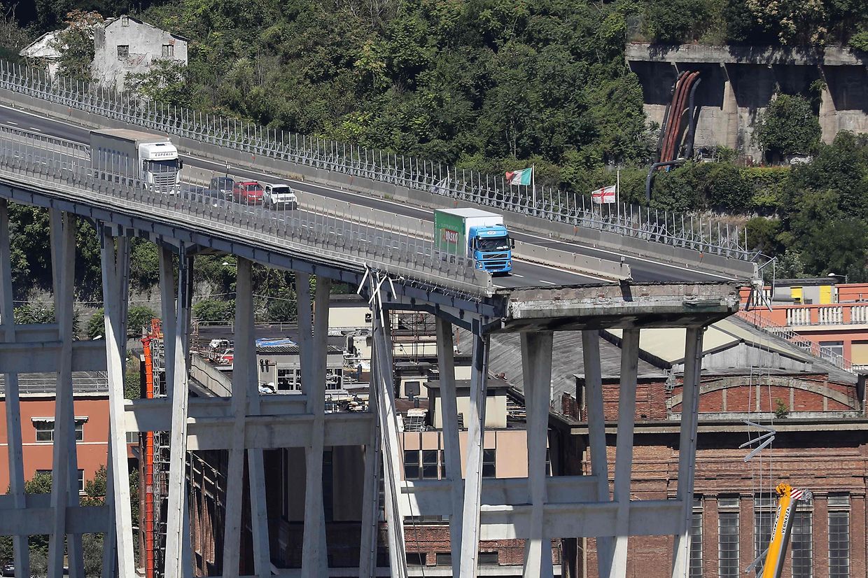 This view taken on August 15, 2018, shows abandoned vehicles on the Morandi motorway bridge the day after a section collapsed in the north-western Italian city of Genoa. - At least 38 people were killed on August 14, when the giant motorway bridge collapsed in Genoa in northwestern Italy. The collapse, which saw a vast stretch of the A10 freeway tumble on to railway lines in the northern port city, was the deadliest bridge failure in Italy for years, and the country's deputy transport minister warned the death toll could climb further. (Photo by Valery HACHE / Piero CRUCIATTI / AFP / AFP)