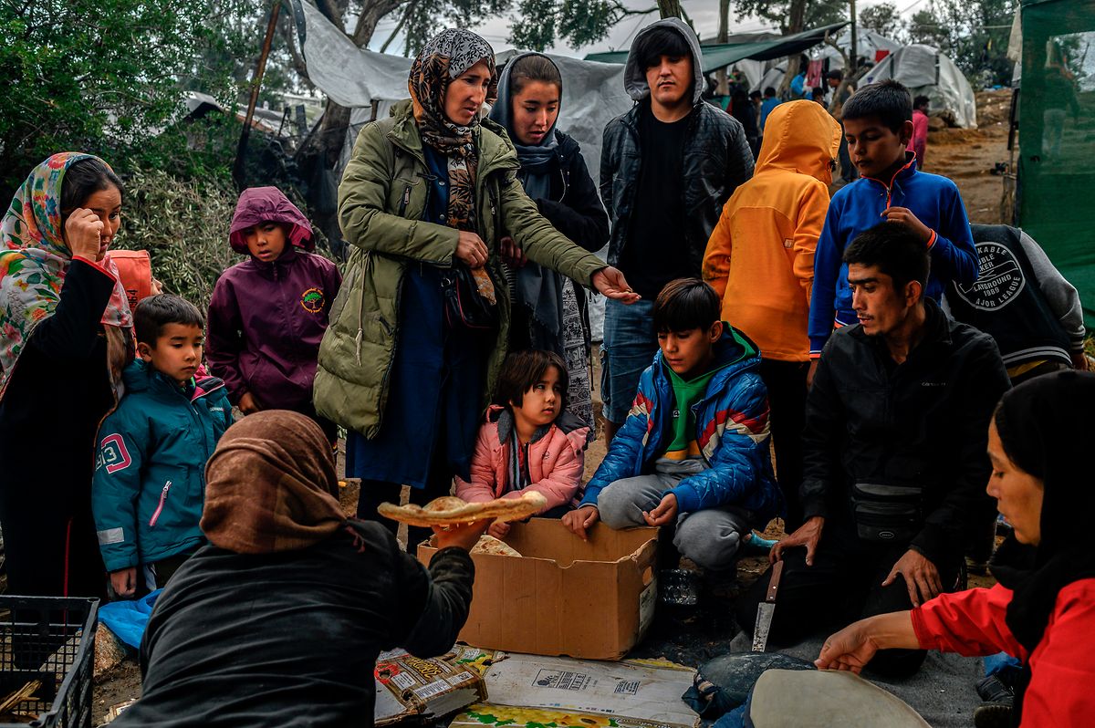 Lesbos: Migranten, darunter viele Kinder, warten darauf, in einem Zwischenlager neben dem Lager Moria auf der Insel Lesbos Brot zu kaufen.