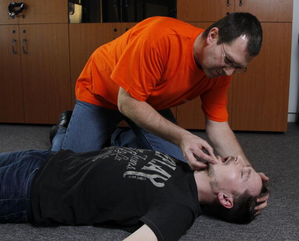 2) Kopf überstrecken: Der Kopf des Opfers sollte überstreckt und dabei– z. B. mit einem Schuh – abgestützt werden. Zudem sollte mit einem Blick in den Mund überprüft werden, ob nichts verschluckt wurde.