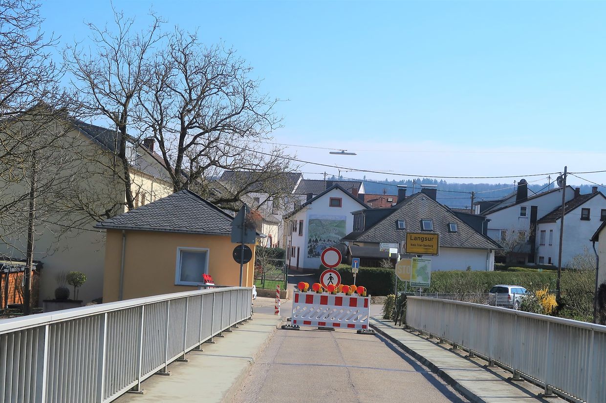 Im deutschen Ort Langsur macht eine Baustellenabsperrung die Durchfahrt unpassierbar. Auch Fußgänger dürfen nicht über die Brücke ins Dorf gehen.