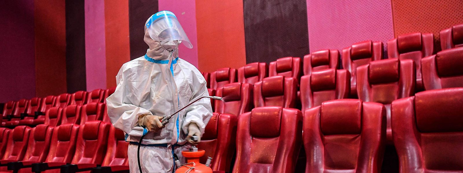 Ein Mitarbeiter versprüht Desinfektionsmittel in einem Kino, als die Stadt nach einem Ausbruch des Covid-19-Coronavirus in Shenyang am 25. April 2022 wieder geöffnet wird. 