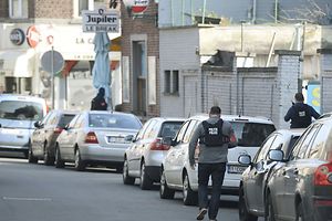 Police officers walk at the site of a shooting in the Dries-Driesstraat street on March 15, 2016 at Forest-Vorst in Brussels. Shots were fired on March 15 at Belgian police in the capital Brussels as they carried out an operation linked to the Paris attacks, Belgian prosecutors told / AFP PHOTO / BELGA / DIRK WAEM / Belgium OUT