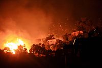 TOPSHOT - A picture taken on August 3, 2021 shows flames rising from a fire spreading in the Aegean coast city of Oren, near Milas, in the holiday region of Mugla, as Turkey struggles against its deadliest wildfires in decades. - The nation of 84 million has been transfixed in horror as the most destructive wildfires in generations erase pristine forests and rich farmland across swaths of Turkey's Mediterranean and Aegean coasts. Tourists have been forced to escape on boats for safety and dozens of villages have been evacuated as wild winds and soaring heat fan the flames. (Photo by STR / AFP)