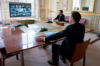 French President Emmanuel Macron (R) attends a video conference call with members of the European Council at the Elysee Palace in Paris, on March 26, 2020, to discuss coordination of EU efforts to tackle the outbreak of COVID-19 (novel coronavius), as well as other issues, including foreign affairs, digital policy and enlargement. - EU leaders will try on March 26 to unify their scattershot response to the COVID-19 epidemic, after hardest-hit Spain, France and Italy called for joint borrowing to share the economic burden. Hundreds of millions of the bloc's citizens are holed up at home, during lockdowns imposed to help slow the pandemic that has killed more than 20,000 Europeans and crippled business life. (Photo by Ian LANGSDON / POOL / AFP)