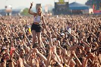 ARCHIV - 03.06.2018, Rheinland-Pfalz, Nürburg: Eine junge Frau steht beim Auftritt der US-amerikanischen Punkband «Rise against» vor der Hauptbühne des Musikfestival «Rock am Ring» auf den Schultern eines Zuschauers. (zu dpa - «Rock am Ring» und «Rock im Park» wegen Corona abgesagt) Foto: Thomas Frey/dpa +++ dpa-Bildfunk +++
