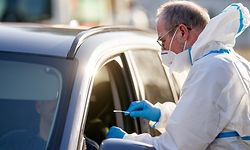 29.03.2021, Rheinland-Pfalz, Mendig: Ein DRK-Mitarbeiter nimmt den Abstrich für Corona-Schnelltests an einer Drive-In-Station durch das Autofenster. Zu den gut 900 Corona-Schnellteststellen in Rheinland-Pfalz gehören auch einige Drive-in-Testzentren. (zu dpa: "Bequem und kontaktarm - Corona-Schnelltests als Drive-in-Angebote"). Foto: Thomas Frey/dpa +++ dpa-Bildfunk +++