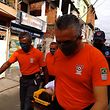 Paramédicos transportam uma mulher para uma ambulância na Favela Paraisopolis, em São Paulo.