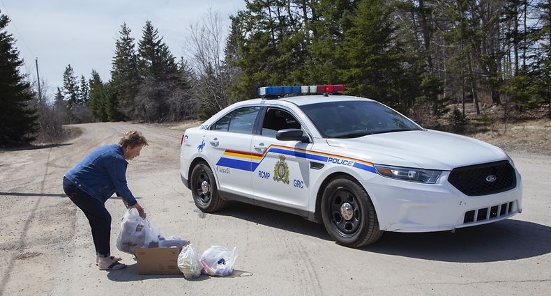 PORTAPIQUE, NS - APRIL 20: Local resident Juanita Corbett delivers food and drinks to police on Portapique Beach Road after Sunday's deadly shooting rampage on April 20, 2020 in Portapique, Nova Scotia Canada. RCMP were blocking access to the road as authorities continue to investigate Canada's worst mass killing. Seventeen people including the gunman died during the rampage, some of which took place in homes along Portapique Beach Road and was scattered through several rural communities in the Maritime provinces.   Tim Krochak/Getty Images/AFP
== FOR NEWSPAPERS, INTERNET, TELCOS & TELEVISION USE ONLY ==