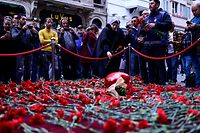 People lay flowers at a makeshift memorial for the victims of November 13 explosion at the busy shopping street of Istiklal in Istanbul on November 14, 2022. - Turkey's interior minister accused the outlawed Kurdistan Workers' Party (PKK) on November 14, of responsibility for a bombing in a busy Istanbul street that killed six people and wounded scores, saying more than 20 people have been arrested. (Photo by Yasin AKGUL / AFP)