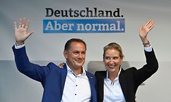 Parliamentary group co-leader of Germany's far-right Alternative for Germany (AfD) party Alice Weidel (R) and the party's co-leader Tino Chrupalla, both the party's top candidates in the upcoming election, wave to supporters at the end of a rally of the AfD party for the launch of the electoral campaign ahead of the September 26 federal elections, in Schwerin, northern Germany, on August 10, 2021. (Photo by John MACDOUGALL / AFP)