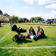 Marina and Andrea sit in the sun with their daughter Sara within a marked area at Islands Brygge in Copenhagen, on May 3, 2020 amid the novel coronavirus COVID-19 pandemic. - Marked areas are to help citizens keep distance. Each field is 40 m2 in which only 10 people can stay. (Photo by Ida Guldbaek Arentsen / Ritzau Scanpix / AFP) / Denmark OUT