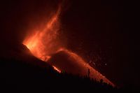 The Cumbre Vieja volcano, pictured at night from El Paso, spews lava, ash and smoke, in the Canary Island of La Palma on October 11, 2021. - It has been almost three weeks since La Cumbre Vieja began erupting, forcing 6,000 people from their homes as the lava scorched its way across 1,200 acres of land. (Photo by JORGE GUERRERO / AFP)