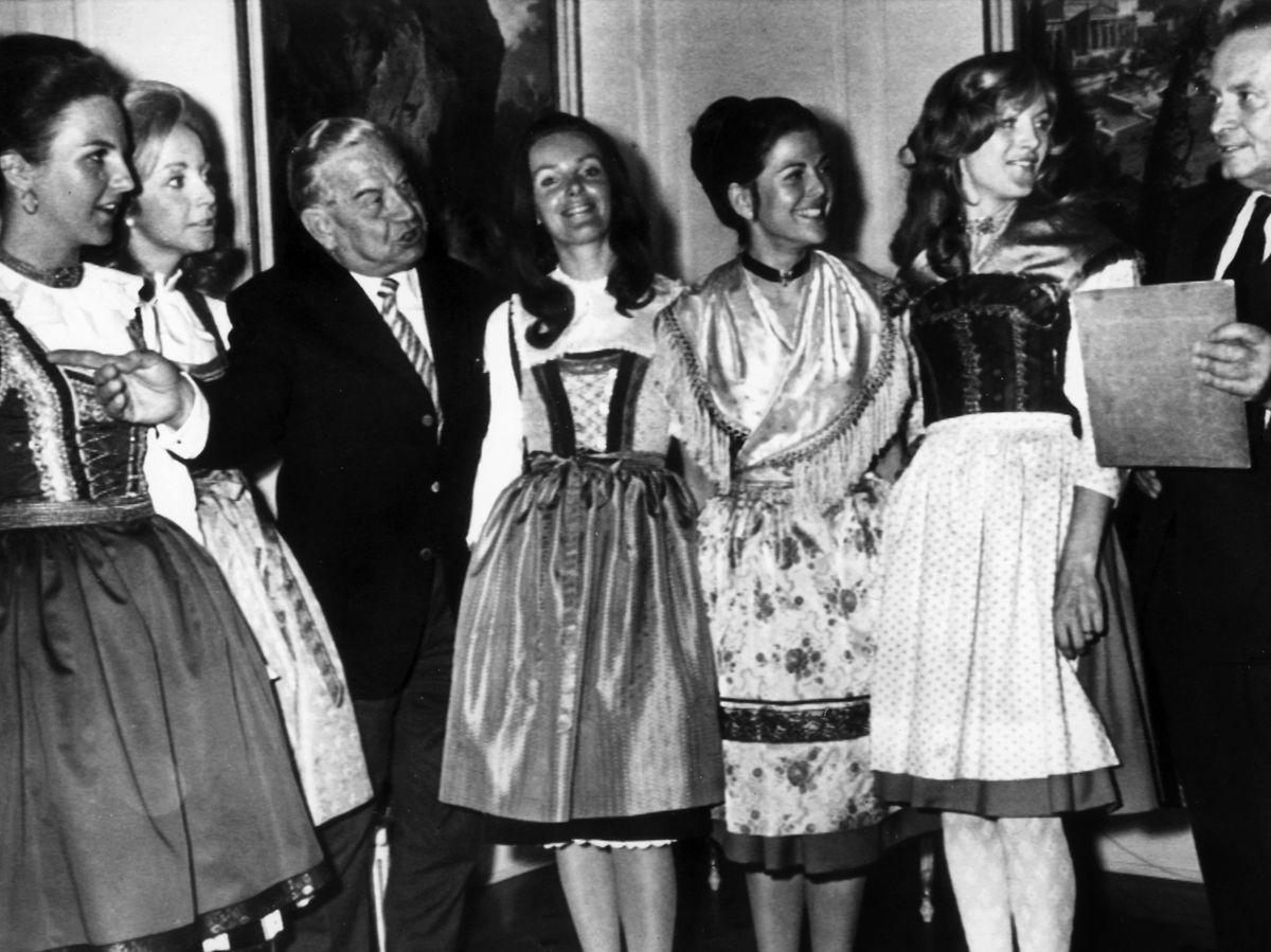 Die spätere Königin Silvia von Schweden (3.v.r.) präsentiert gemeinsam mit anderen Hostessen dem bayerischen Ministerpräsidenten Alfons Goppel (l.) und dem deutschen NOK-Präsidenten Willi Daume (r.) am 10. April 1972 in München die bayerischen Trachten, in denen die Mädchen bei den Olympischen Spielen 1972 in München die Medaillen überreichen werden.