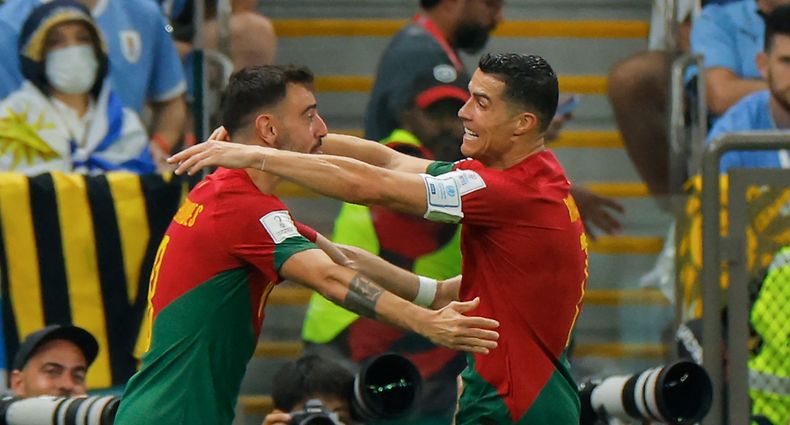 Portugal's forward #07 Cristiano Ronaldo (R) celebrates with Portugal's midfielder #08 Bruno Fernandes after he scored his team's first goal during the Qatar 2022 World Cup Group H football match between Portugal and Uruguay at the Lusail Stadium in Lusail, north of Doha on November 28, 2022. (Photo by Odd ANDERSEN / AFP)