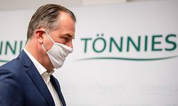 ARCHIV - 13.05.2020, Nordrhein-Westfalen, Rheda-Wiedenbrück: Clemens Tönnies, geschäftsführender Gesellschafter bei Deutschlands größtem Schlachtbetrieb Tönnies, trägt bei einer Pressekonferenz bei Tönnies eine Schutzmaske von Schalke 04. Beim Schlachtereibetrieb Tönnies in Rheda-Wiedenbrück sind seit Anfang der Woche 400 Mitarbeiter positiv auf das Coronavirus getestet worden. Das sagte eine Sprecherin des Kreises Gütersloh am Mittwoch. Foto: David Inderlied/dpa +++ dpa-Bildfunk +++