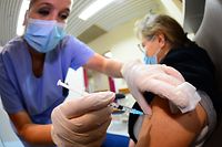 A nurse injects a dose of Pfizer/BioNTech Comirnaty Covid-19 vaccine to a colleague on January 8, 2021 in the vaccination centre of the Haut-Leveque hospital in Pessac, near Bordeaux. (Photo by MEHDI FEDOUACH / AFP)