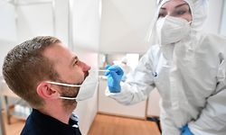 28.04.2021, Thüringen, Erfurt: Eine Mitarbeiterin in Schutzkleidung macht einen Abstrich im Corona-Testzentrum in der Messe. Betrieben wird das Schnelltestzentrum vor allem für Besucher der Bundesgartenschau in der Messehalle 3. Geplant ist eine Testkapazität von 5.000 Personen pro Tag, dazu wurden 20 Stationen aufgebaut. Geöffnet hat das Zentrum für jedermann montags bis sonntags von 7:30 bis 20:30 Uhr. Foto: Martin Schutt/dpa-Zentralbild/dpa +++ dpa-Bildfunk +++