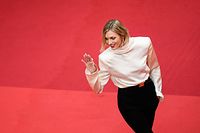 Polish model Anja Rubik waves as she arrives for the screening of the film "Kaibutsu" (Monster) during the 76th edition of the Cannes Film Festival in Cannes, southern France, on May 17, 2023. (Photo by LOIC VENANCE / AFP)