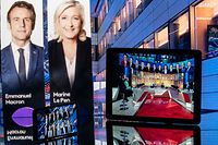TOPSHOT - This photograph taken in Toulouse, southwestern France on April 10, 2022 shows screens displaying TV shows showing the projected results after the close of polling stations in the first round of the French presidential election. (Photo by Lionel BONAVENTURE / AFP)