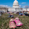The lawn outside the US Capitol is covered with 7,000 pairs of empty shoes to memorialize the 7,000 children killed by gun violence since the Sandy Hook school shooting, in a display organized by the global advocacy group Avaaz, in Washington, DC, March 13, 2018. / AFP PHOTO / SAUL LOEB