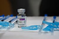 A bottle of the AstraZeneca Covid-19 vaccine sits on a table next to syringes during a mass vaccination campaign for people between ages of 50 to 55 in Vigo, northwestern Spain, on March 13, 2021. (Photo by MIGUEL RIOPA / AFP)