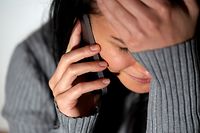 people, helpline and domestic violence concept - close up of unhappy woman crying and calling on smartphone