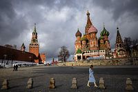 A woman walks outside the Kremlin, Red Square and St. Basil's Cathedral in central Moscow on February 22, 2022. - Russian President Vladimir Putin said on February 22 that he does not plan to restore Russia's empire, a day after he ordered Russian troops to be sent to eastern Ukraine and questioned Ukraine's sovereignty. (Photo by Dimitar DILKOFF / AFP)