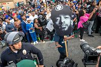 The procession for Nipsey Hussle passes his Marathon Clothing store after his memorial at the Staples Center in Los Angeles, California, on April 11, 2019. - 4 people shot and 1 dead during the procession LAPD reported on late April 11, 2019. The Grammy-nominated artist was killed in front of The Marathon Clothing store he founded in 2017. (Photo by Kyle Grillot / AFP)