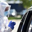 A health worker takes a sample from a person sitting in a car at a new coronavirus COVID-19 testing station for travelers from the motorway at the motorway service area Hochfelln near Ruhpolding, southern Germany, on July 30, 2020. (Photo by Christof STACHE / AFP)