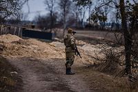 Um soldado ucraniano observa através de uns binóculos a posição do exército russo numa aldeia, a leste da cidade de Brovary.