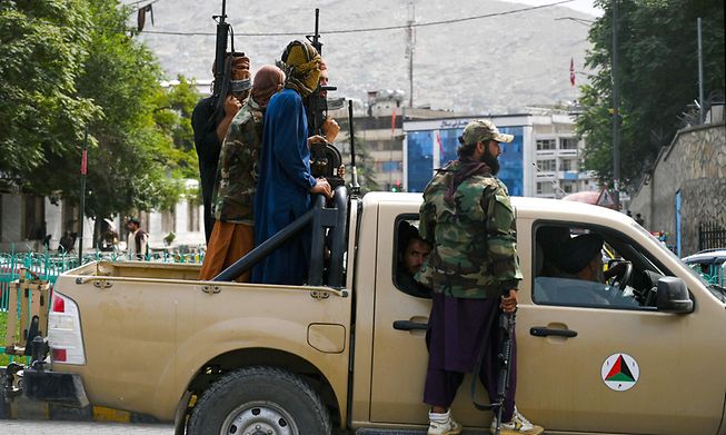 Taliban fighters patrol along a street in Kabul on Tuesday