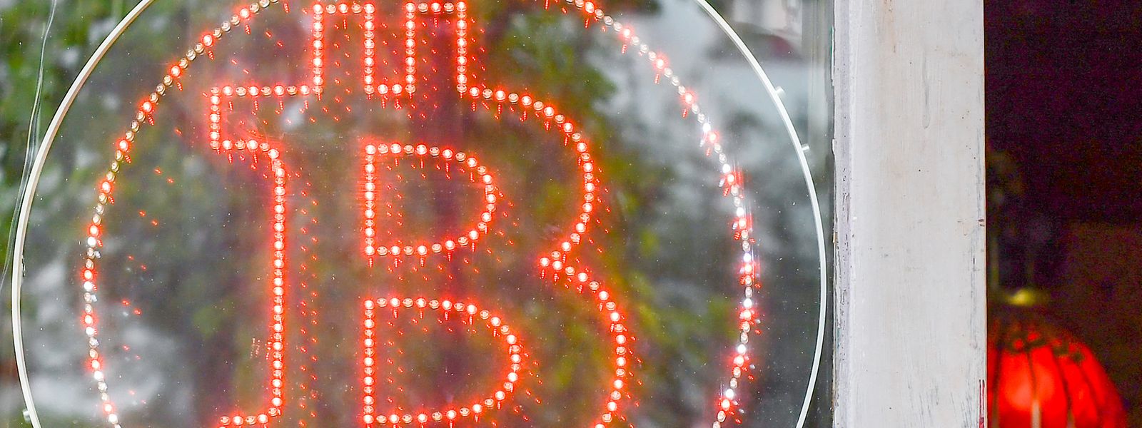 Ein Bitcoin-Logo hängt im Schaufenster einer Kneipe in Kreuzberg. 
