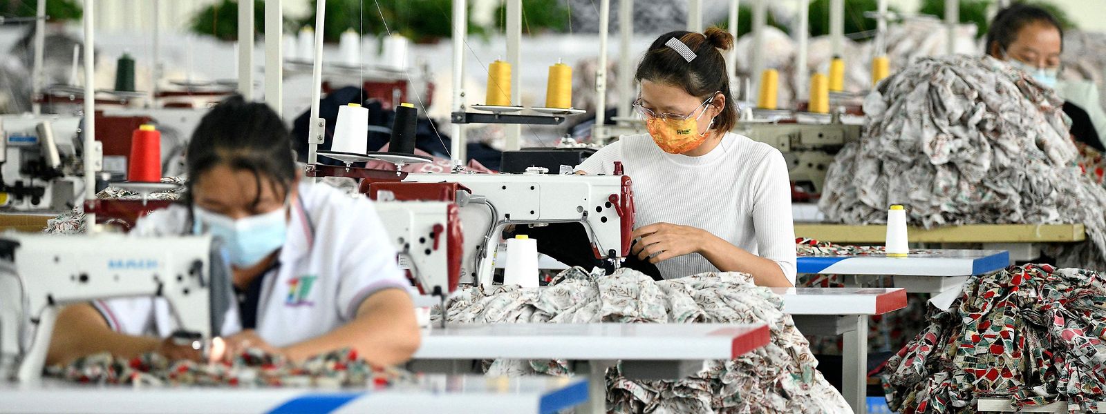 This photo taken on September 21, 2022 shows employees working at a textile factory in Anlong in China's southwestern Guizhou province. (Photo by AFP) / China OUT